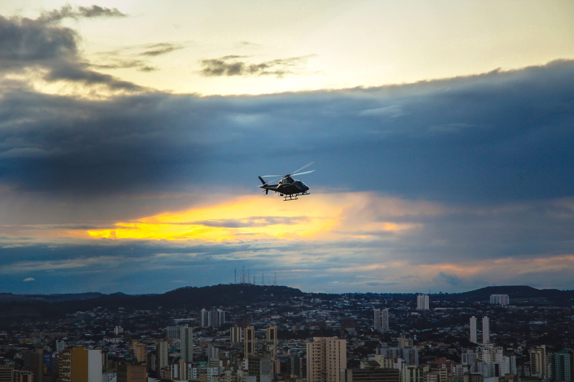 Helicóptero sobrevoa a cidade de Goiânia durante o pôr do sol
