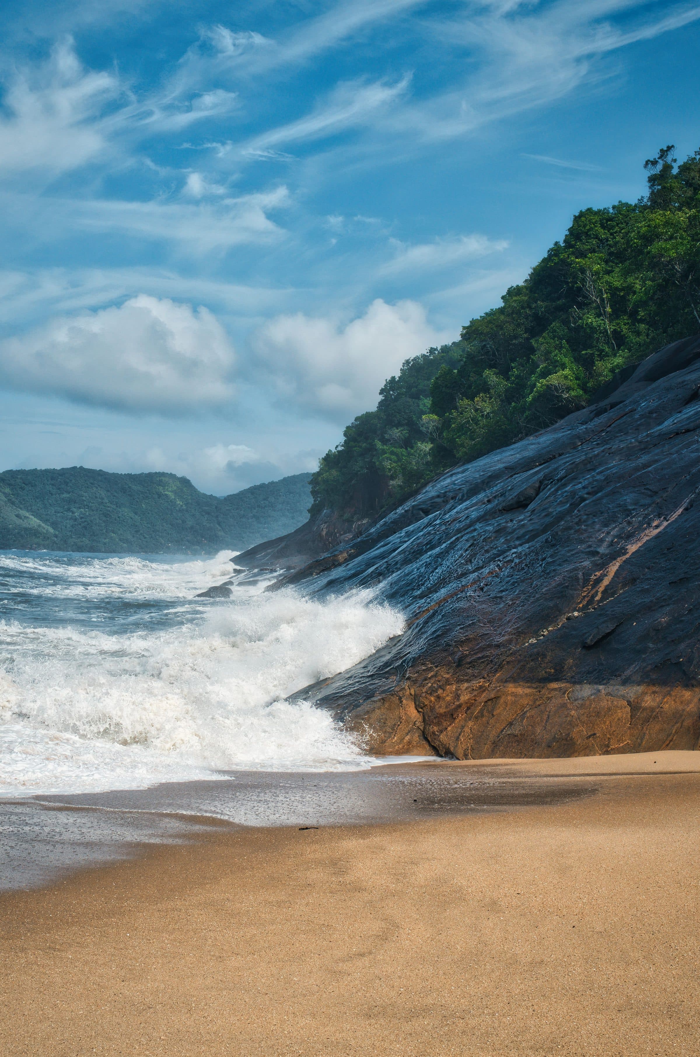 Ondas quebrando contra falésias em praia de Ubatuba