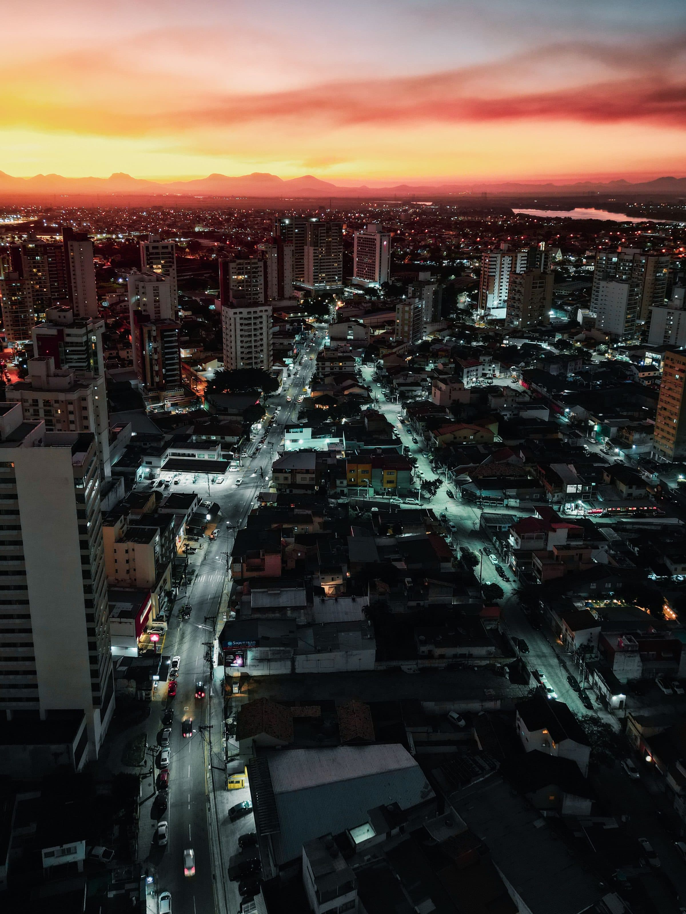Vista aérea de Campos dos Goytacazes ao pôr do sol com as luzes da cidade