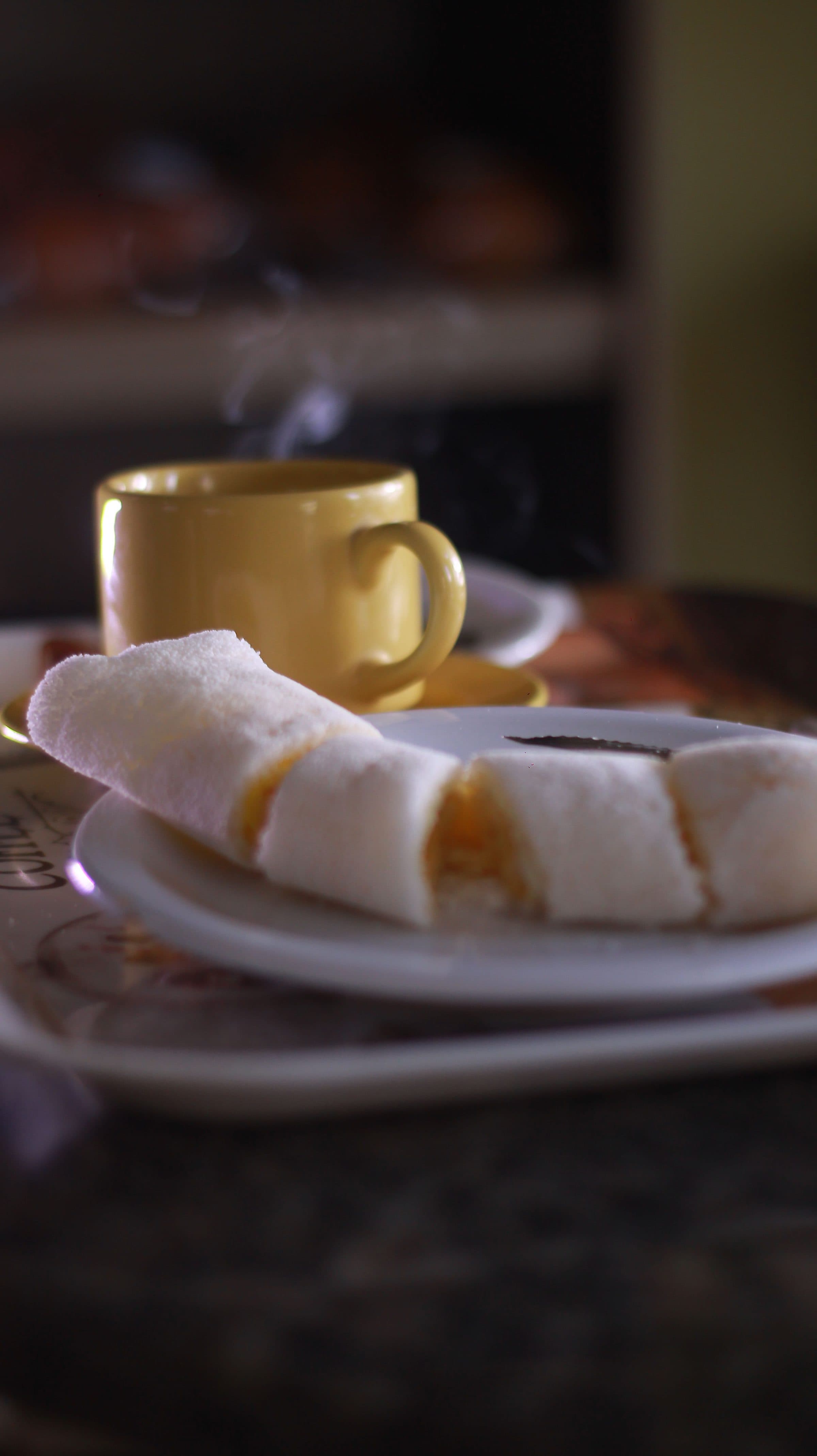 Xícara de café quente acompanhada de tapioca servida no prato