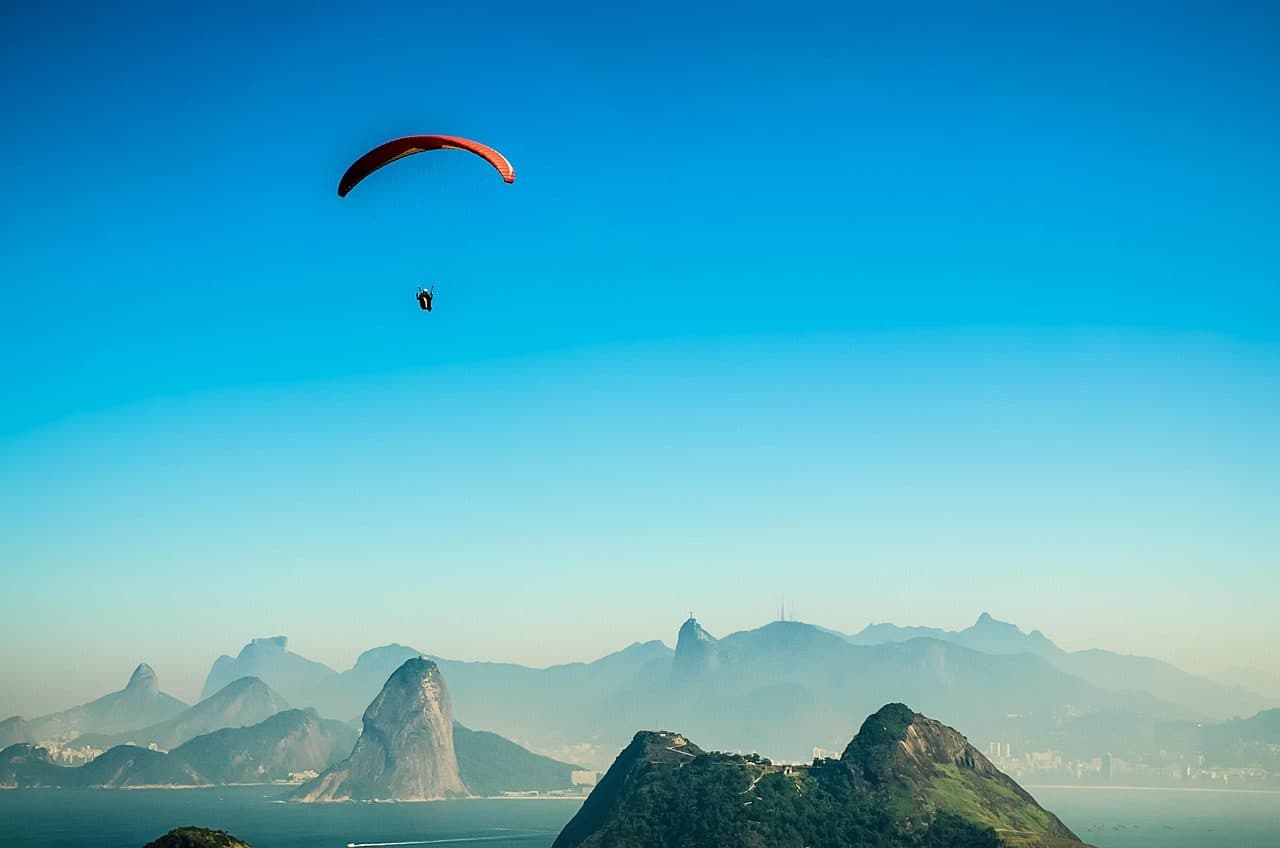 Voo de parapente sobre o Parque da Cidade em Niterói, com vista para a baía e o Cristo Redentor