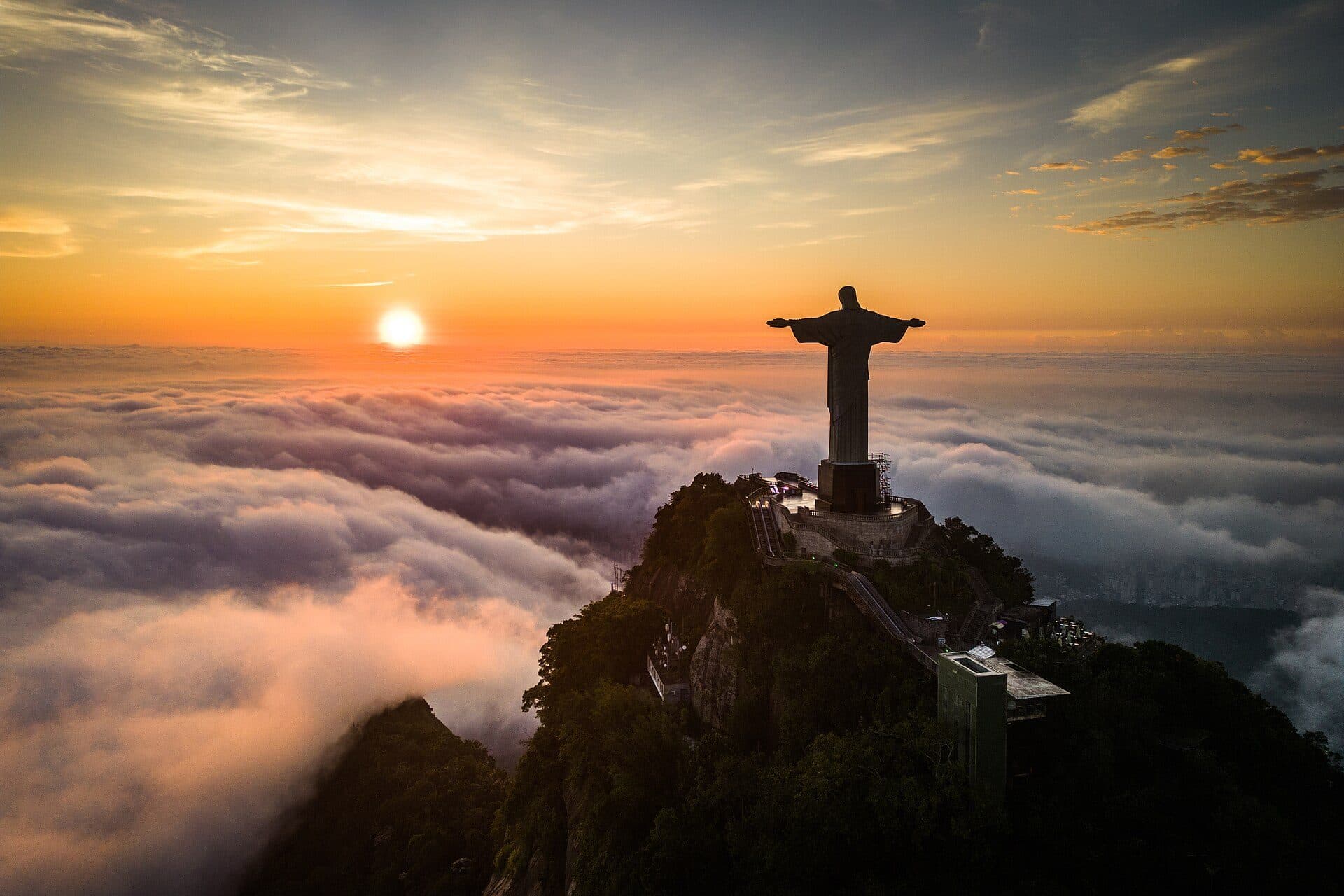 Estátua do Cristo Redentor vista acima de uma camada de nuvens