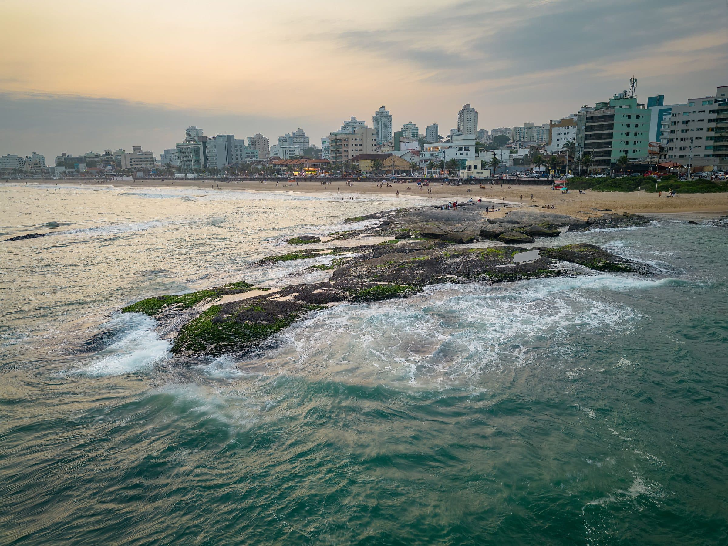 Vista aérea da praia e dos prédios de Macaé durante o pôr do sol