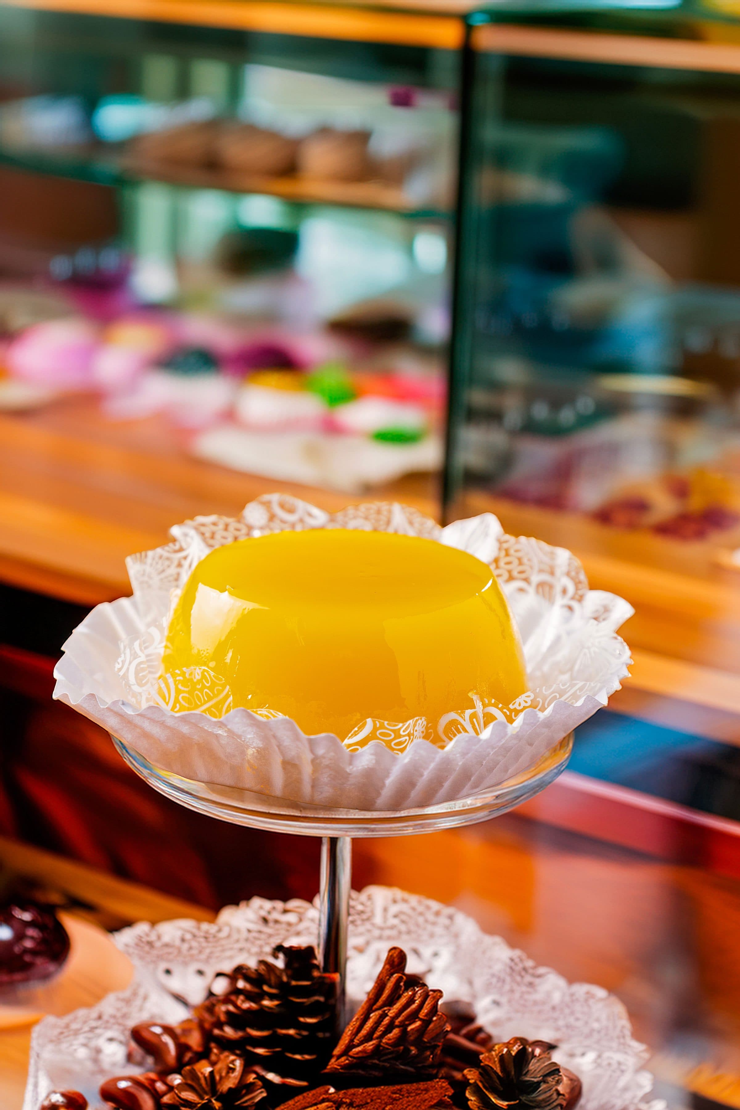 Doce amarelo exposto em suporte de andares na vitrine de uma confeitaria