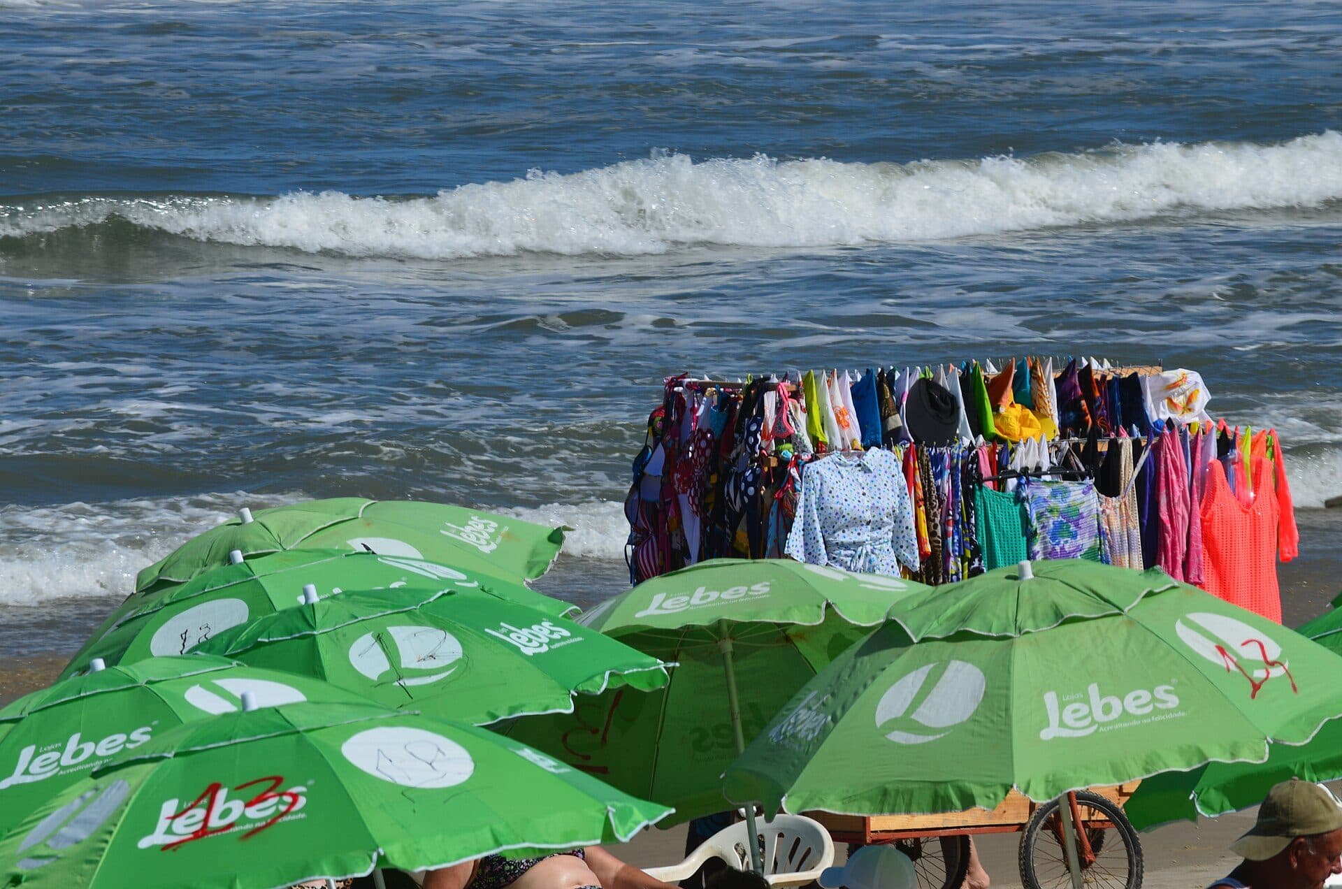 Faixa de areia da Praia de Tramandaí cheia de banhistas em dia movimentado