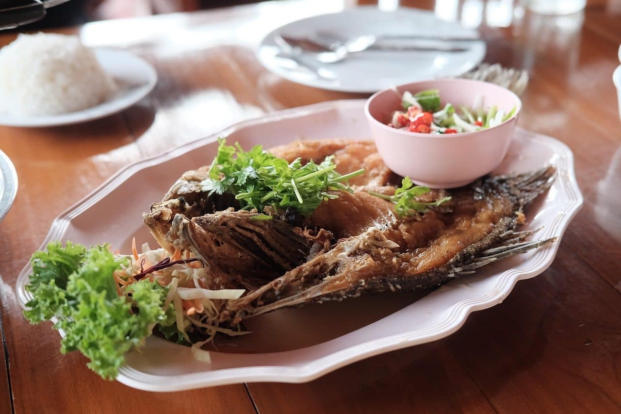 Peixe frito inteiro coberto com molho de peixe