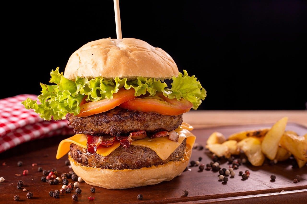 Hambúrguer de carne servido com batatas fritas