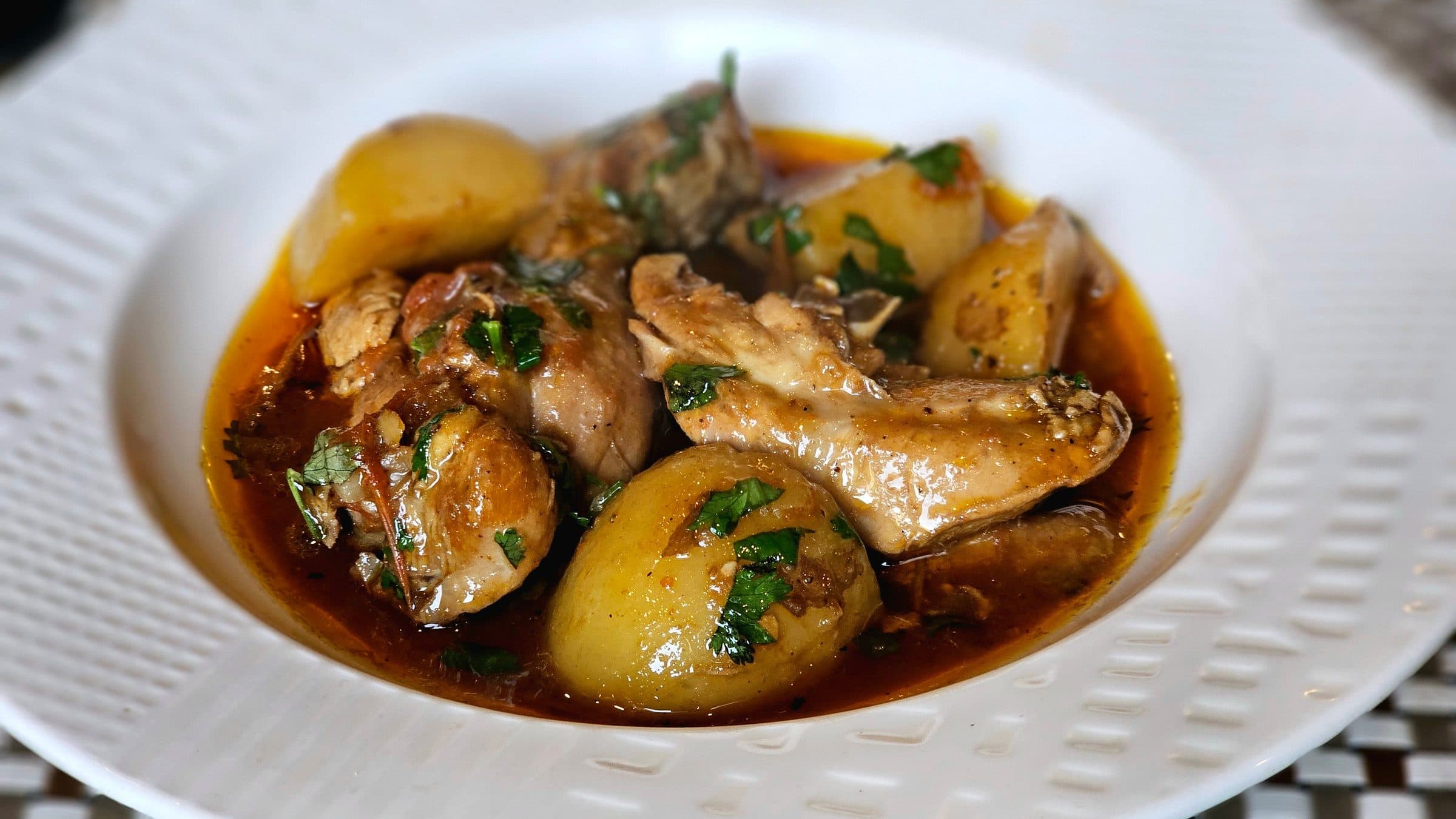 Prato de ensopado de frango com batatas e ervas