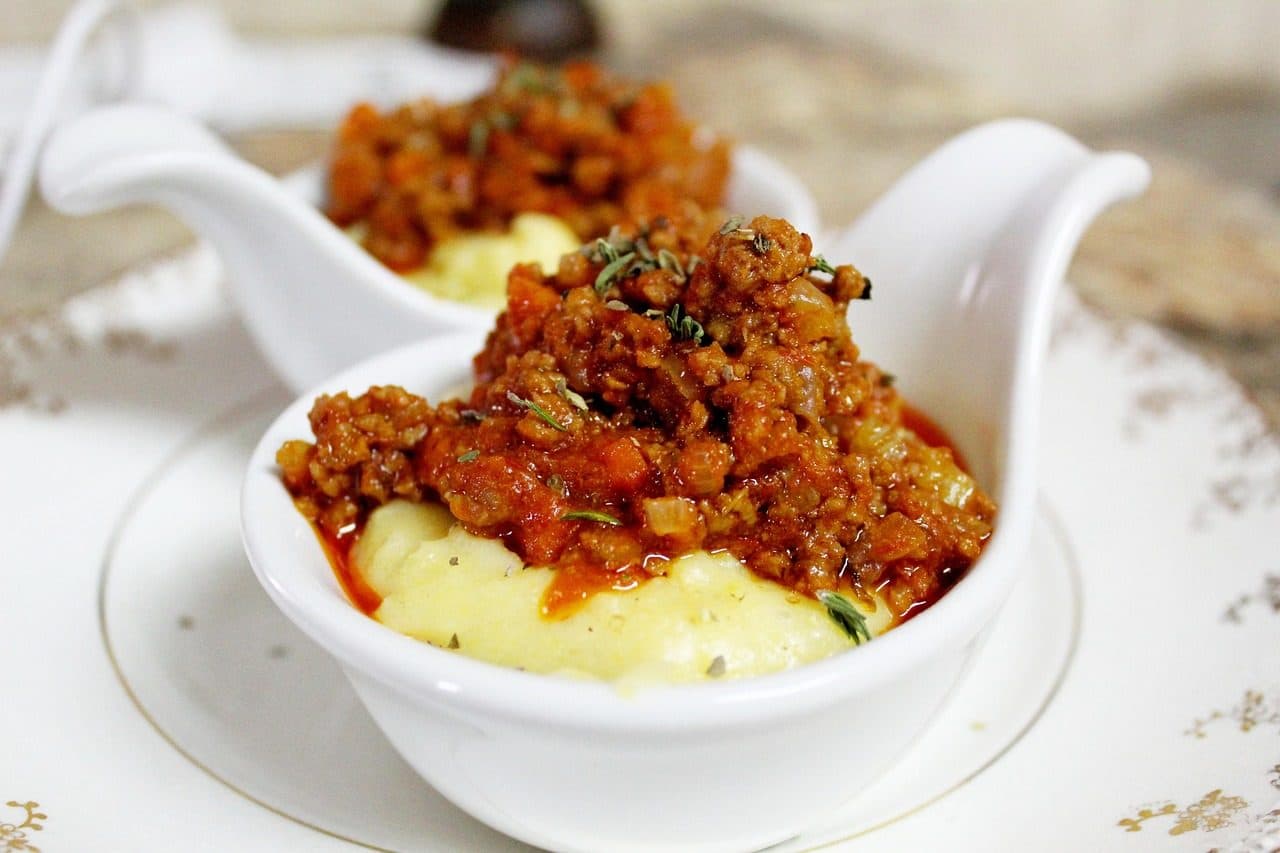 Porção de polenta com molho de tomate e carne moída