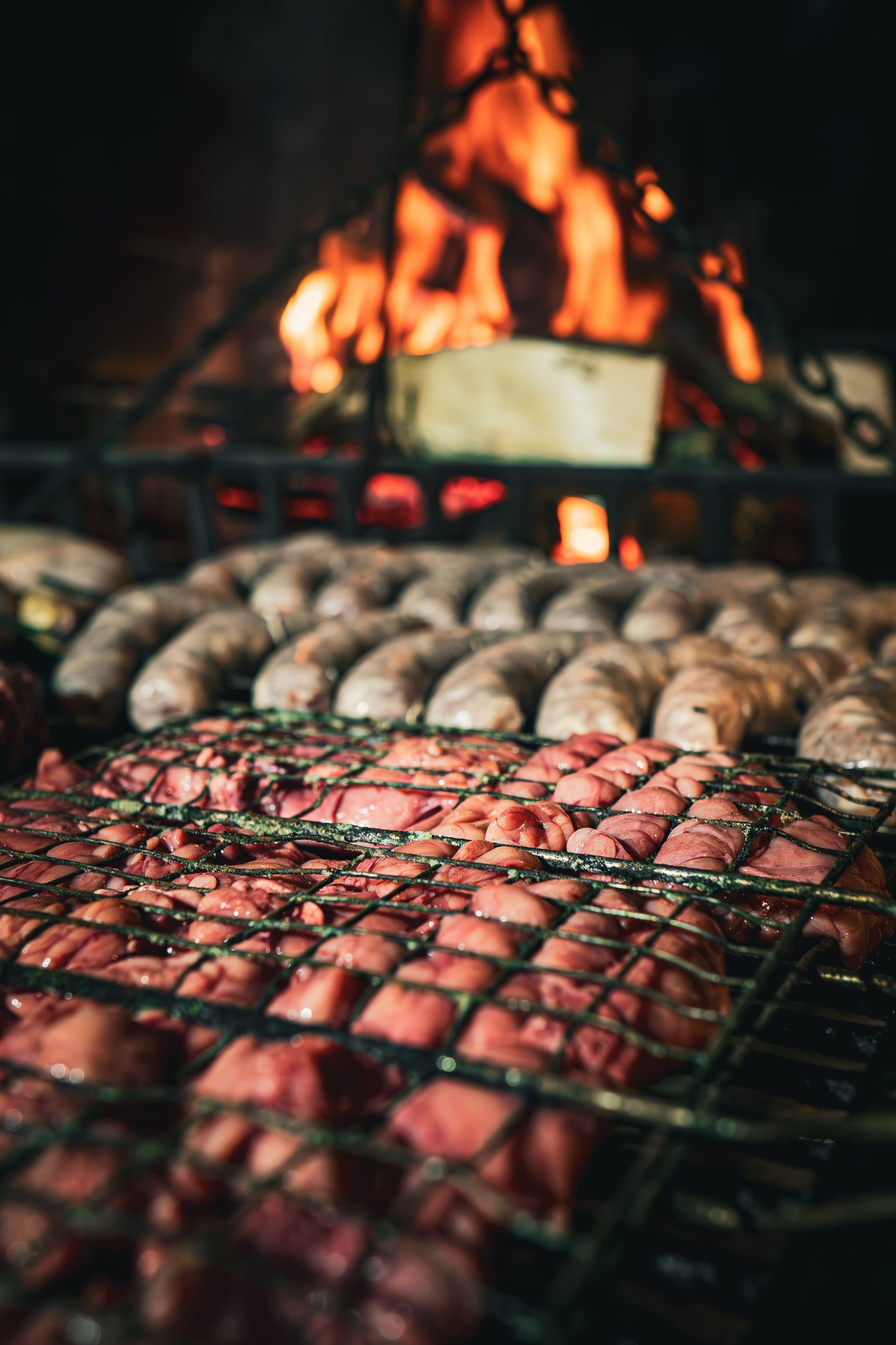 Variedade de carnes assando sobre chamas em um churrasco uruguaio