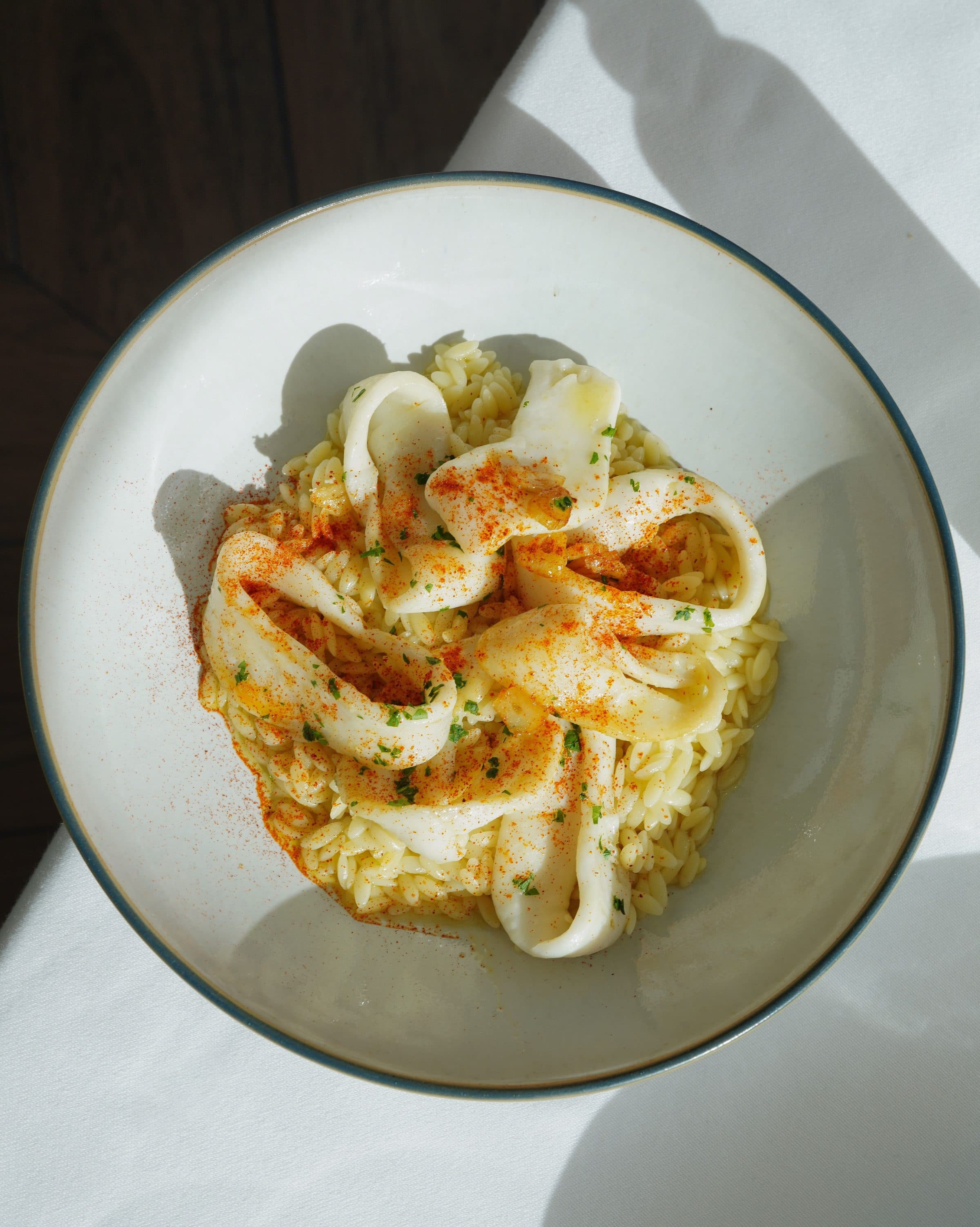 Vista superior de risoto de tinta de lula servido em uma tigela sob luz natural