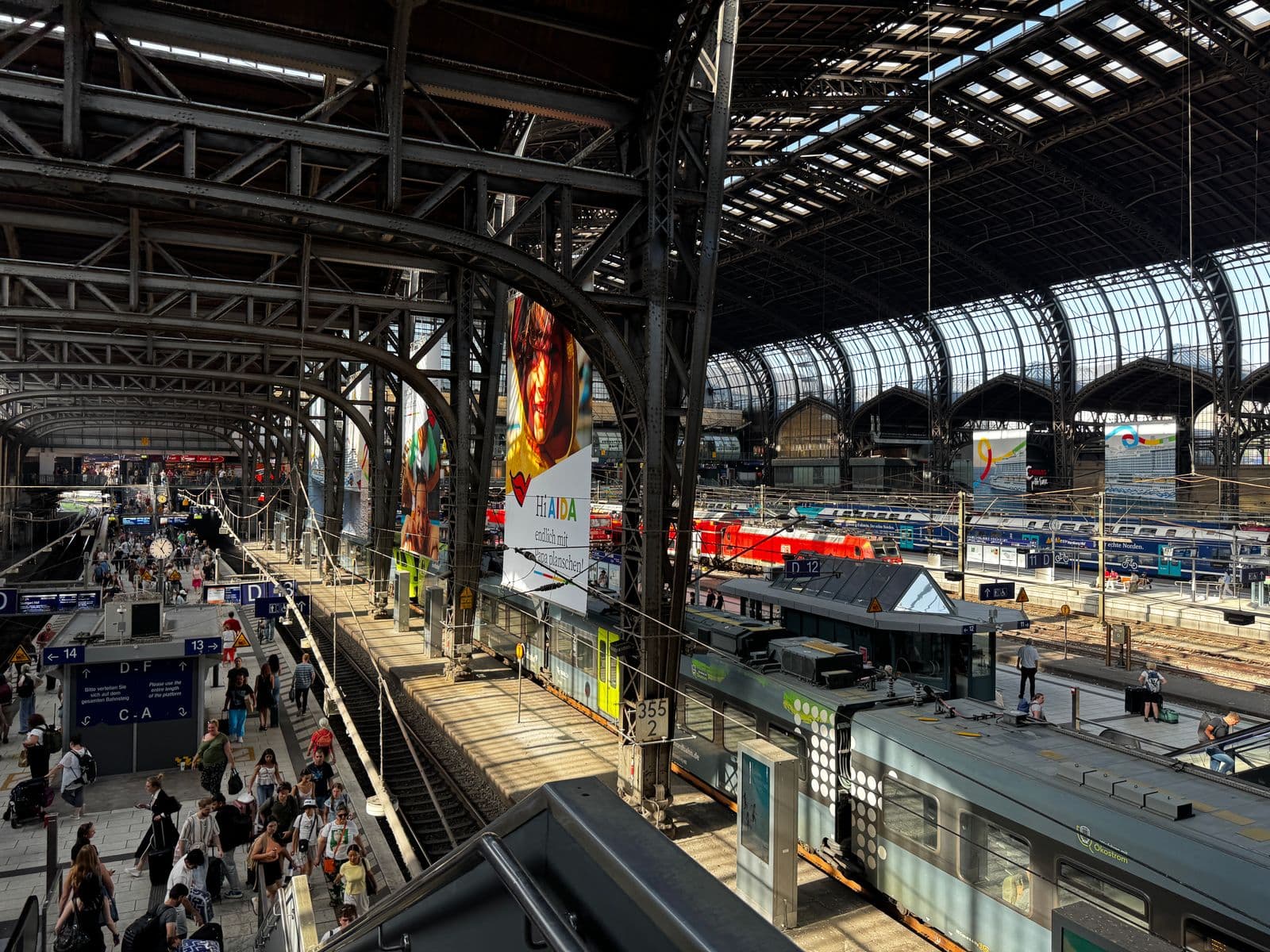 Estação de trem movimentada, com passageiros na plataforma